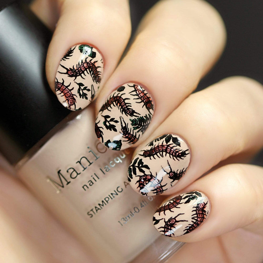 A manicured hand with slithering centipedes holding a polish by Maniology (m159).