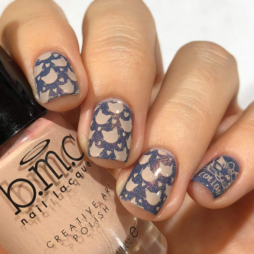 A manicured hand in glitters with cats design holding a polish.