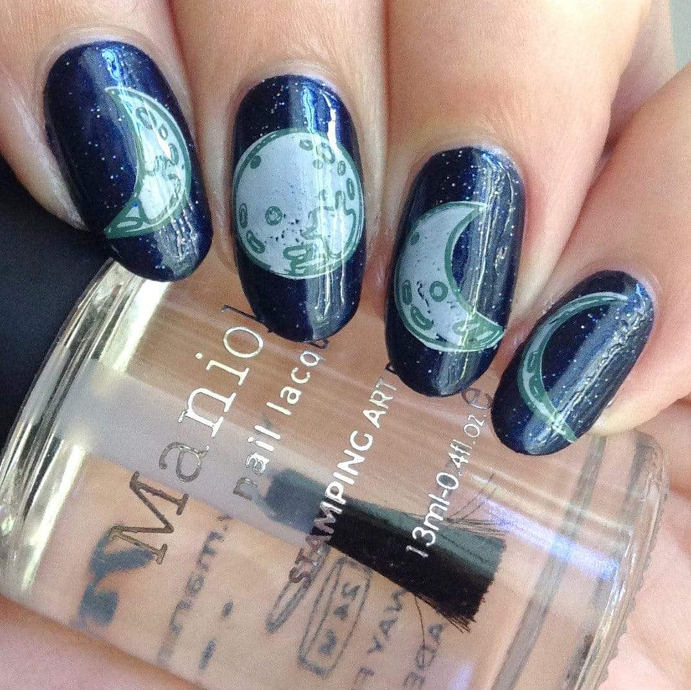 A manicured hand with Crystal moon design holding a stamping polish by Maniology (m119).
