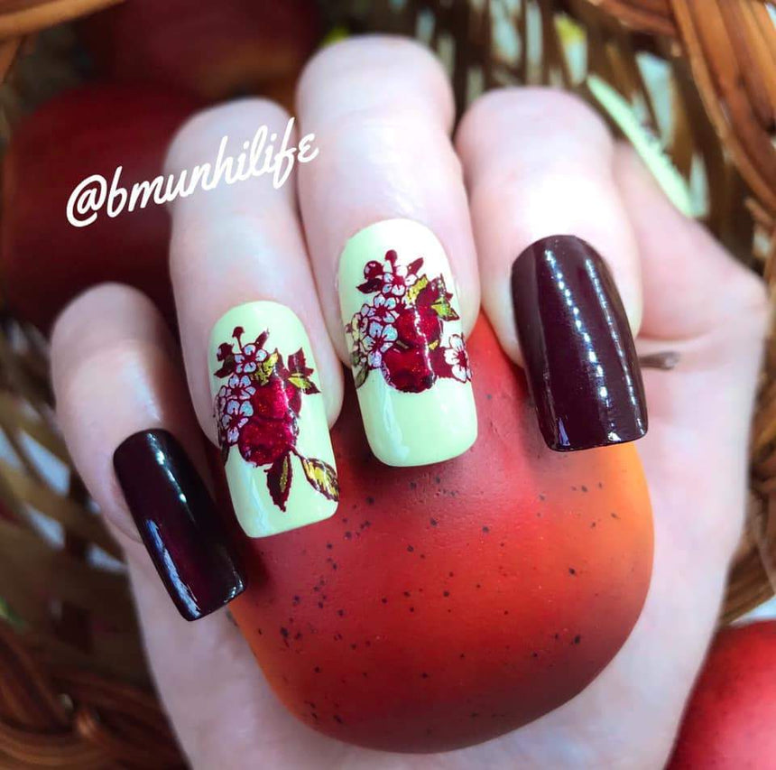 A manicured hand with florals Harvest Blooms design (m075) by Maniology.