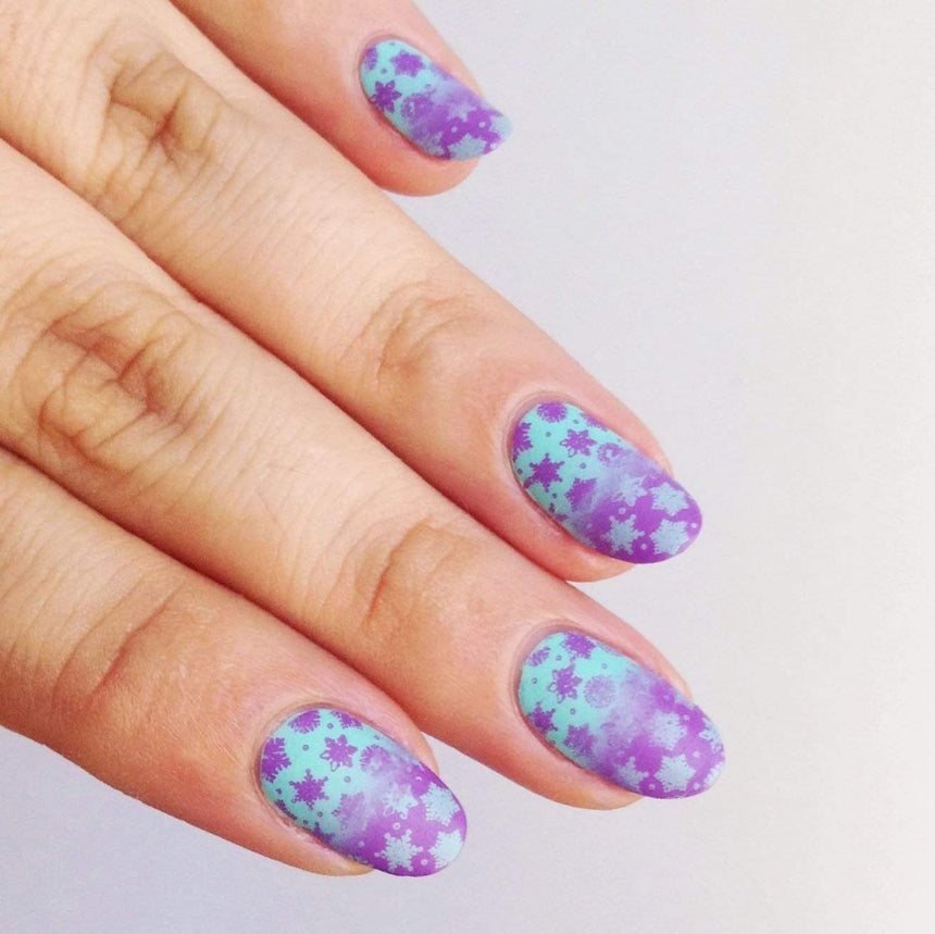 A manicured hand made with icy teal blue Stamping Polish Frosty (B306).