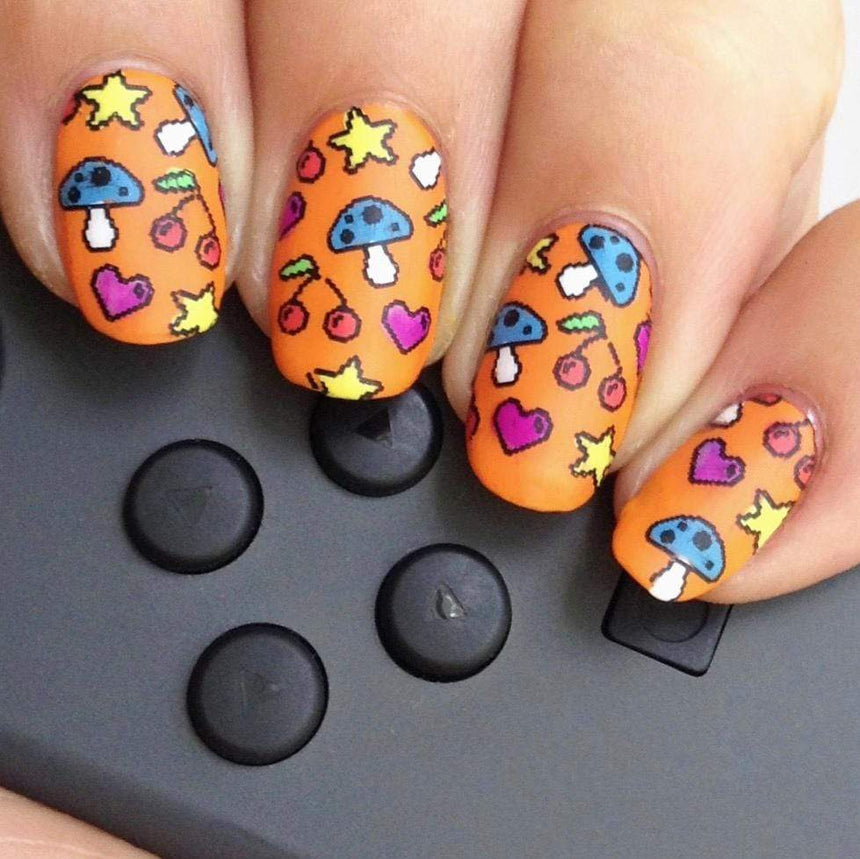 A manicured hand in orange with a variety of arcade graphics design by Maniology (m050).
