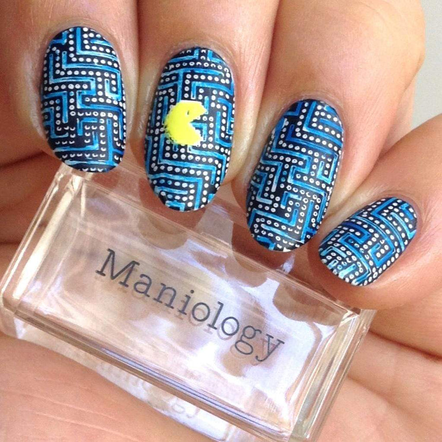 A manicured hand with arcade graphics design holding a stamper by Maniology (m050).