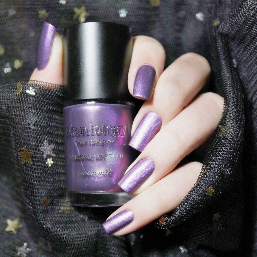 A manicured hand holding a Dearest Aurora stamping polish by Maniology