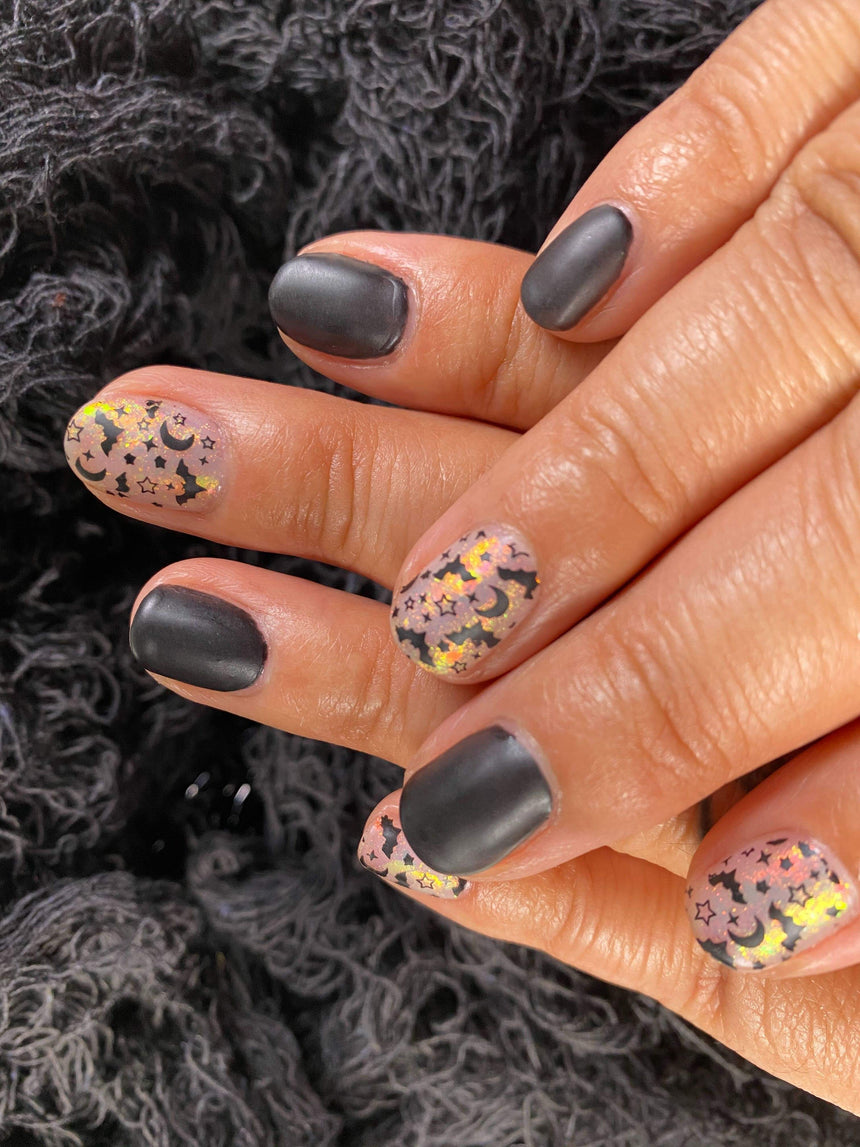 A manicured hand with Transparent Orange Iridescent Flakies by Maniology Illusion (NA027).