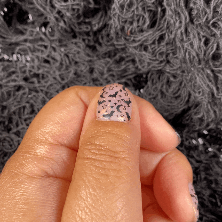 A manicured hand with Transparent Orange Iridescent Flakies by Maniology Illusion (NA027).