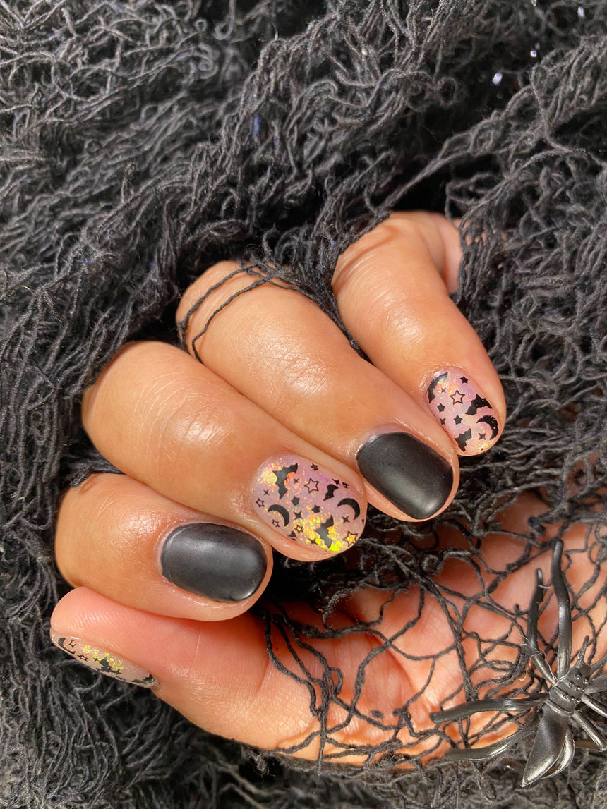 A manicured hand with Transparent Orange Iridescent Flakies by Maniology Illusion (NA027).