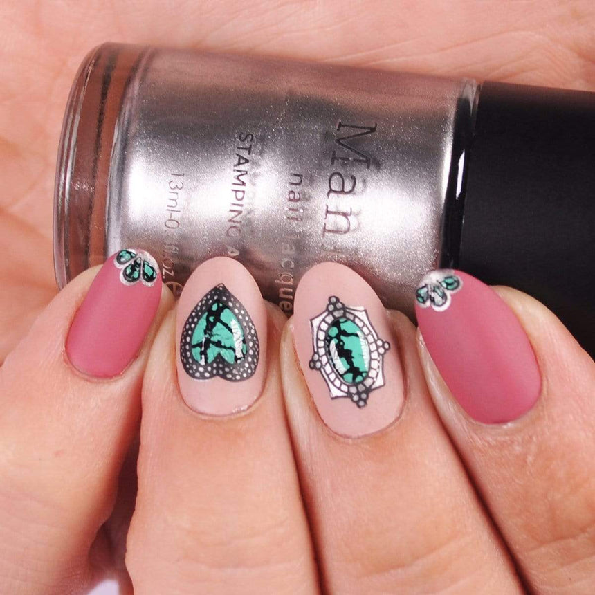 A manicured hand holding a silky silver stamping polish Pewter (B323) by Maniology.