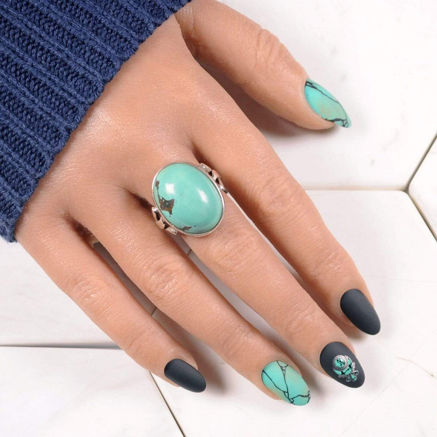 A manicured hand made with Green Stamping Polish Turquoise (B324) by Maniology.