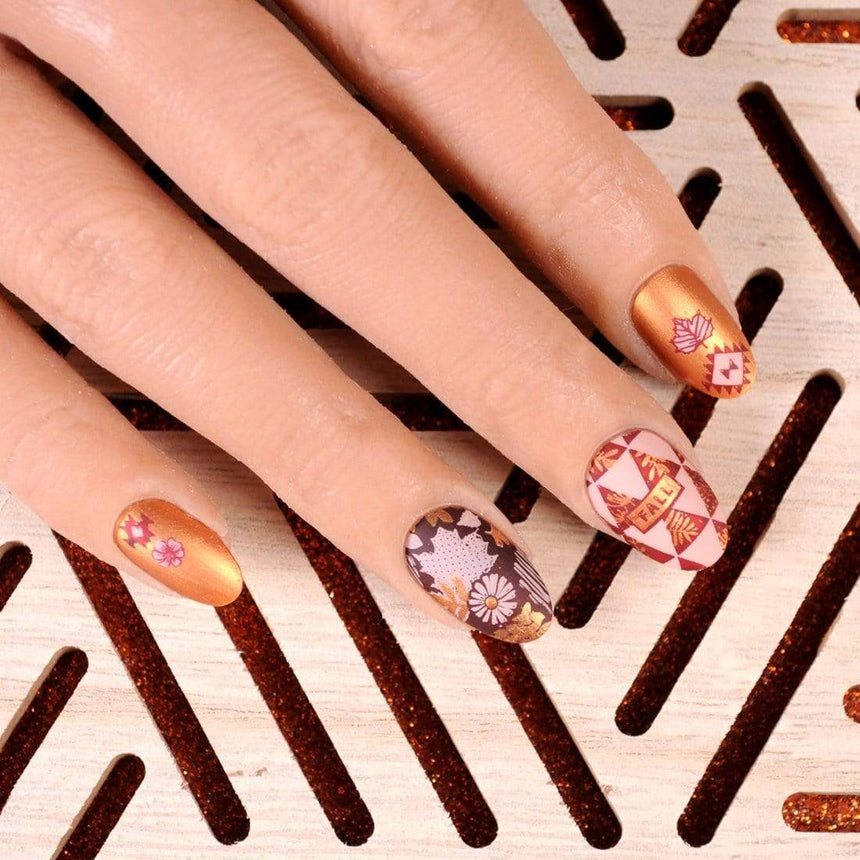A manicured hand with Copper Orange Stamping Polish.