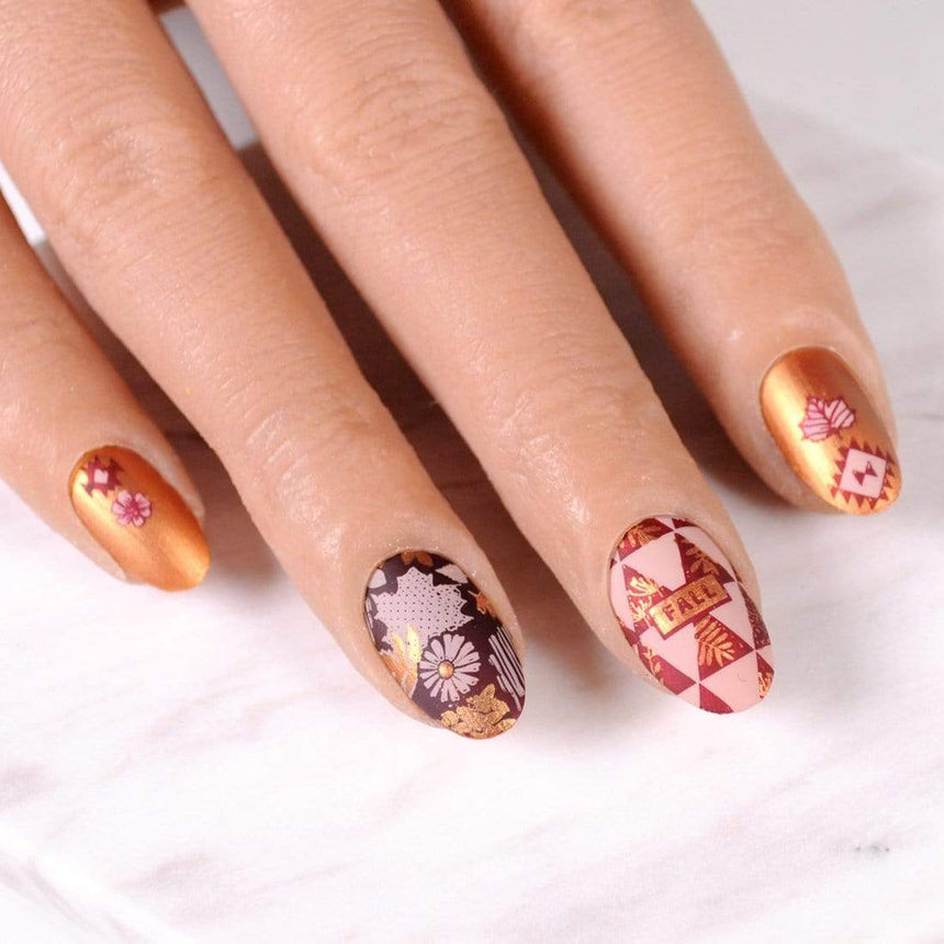 A manicured hand with Copper Orange Stamping Polish.