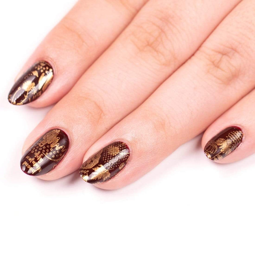 A manicured hand with Copper Orange Stamping Polish.