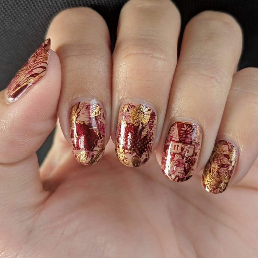 A manicured hand with Copper Orange Stamping Polish.