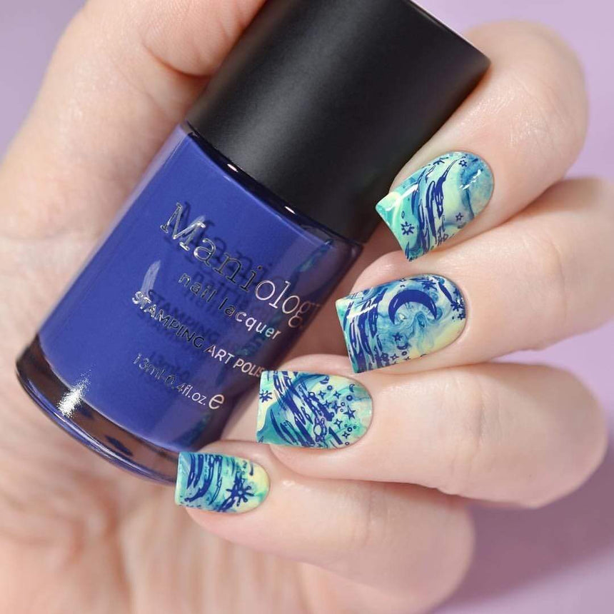 A manicured hand with Negative Space: Starry Night design holding a polish by Maniology (m024).