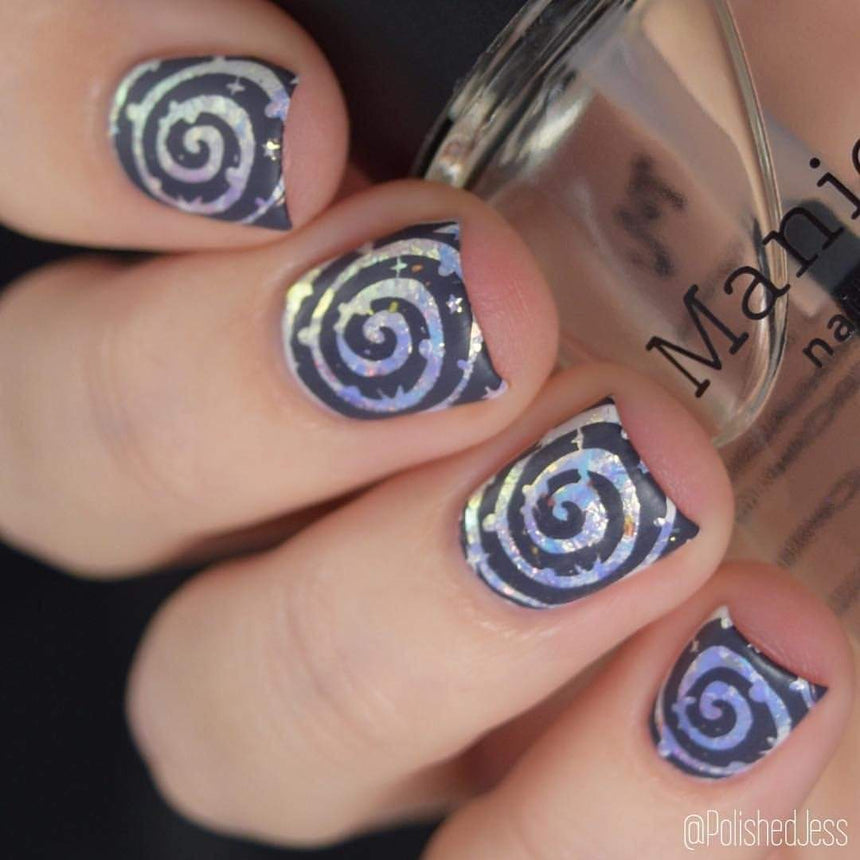 A manicured hand with Negative Space: The Crack in Space designs holding a polish by Maniology (m025).