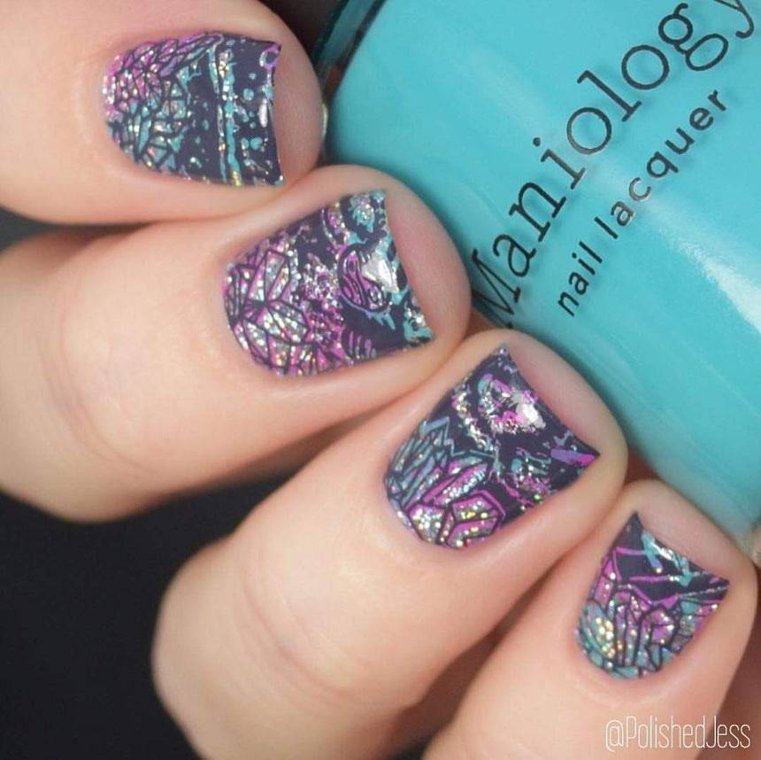 A manicured hand with Negative Space: The Crack in Space designs holding a polish by Maniology (m025).