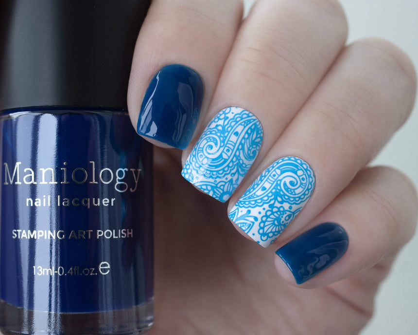 A manicured hand holding Sheer Blue Stamping Polish from Rainbow Splash Collection Ocean Depth (B276) by Maniology.