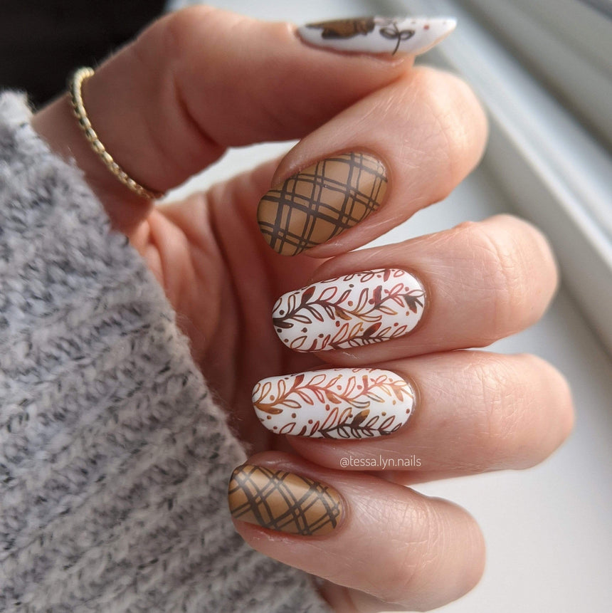 A fall inspired manicure featuring warm colors and leaves.