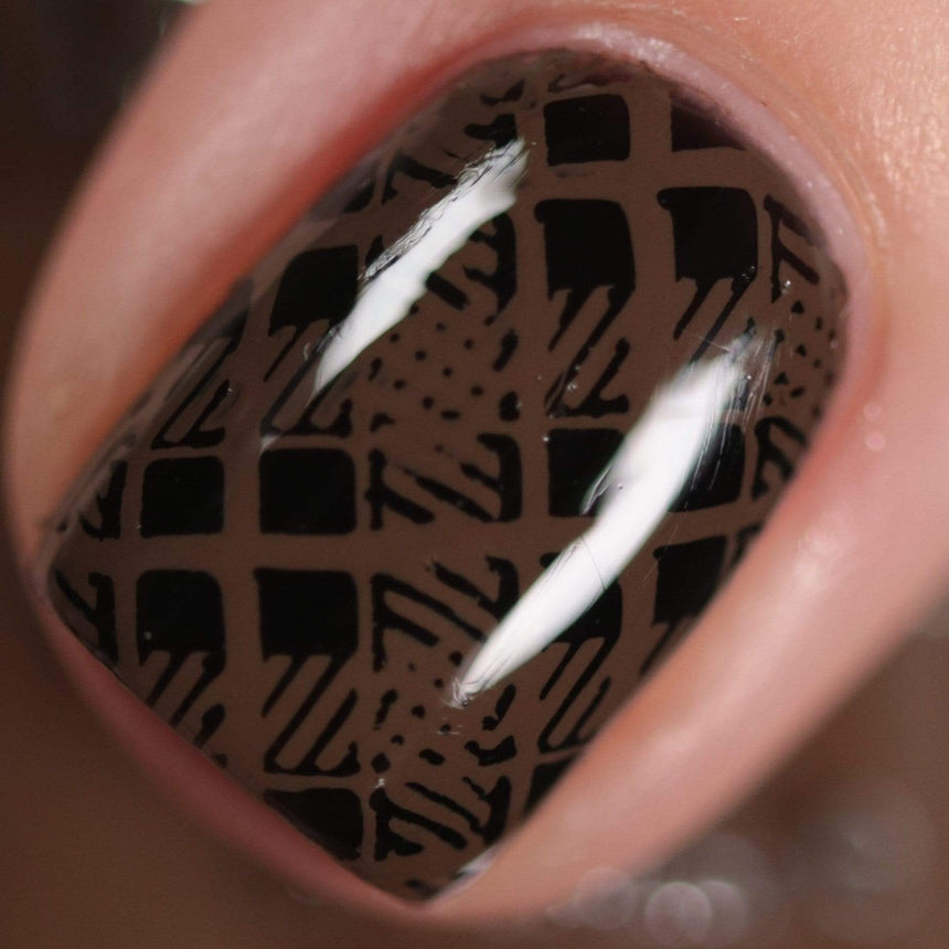 A manicured hand made with warm chocolate brown stamping polish from Sugar + Spice collection by Maniology (B351).