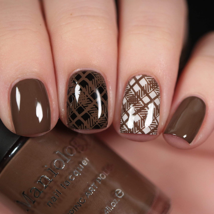 A manicured hand made with warm chocolate brown from Sugar + Spice collection holding a polish by Maniology (B351).