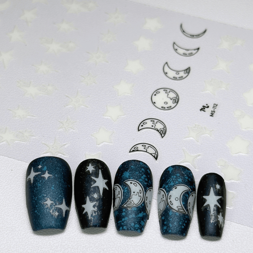 Nail art with star and moon designs on a white background with star patterns.