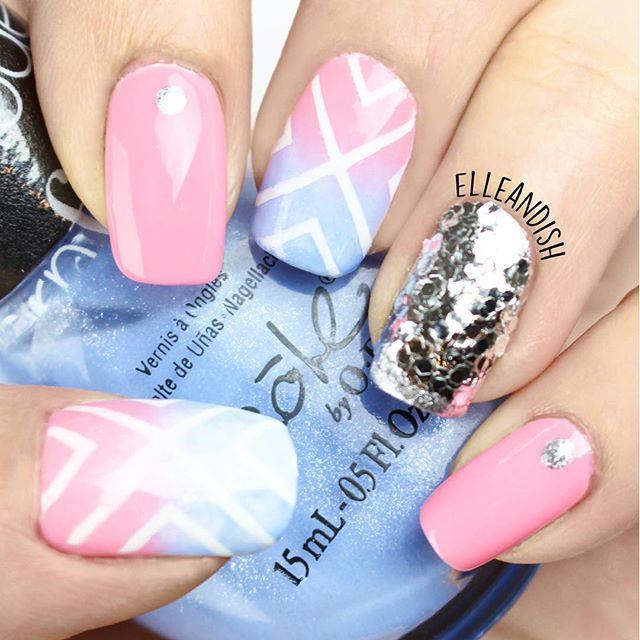 A manicured hand in blue and pink (elleandish) design holding a polish.