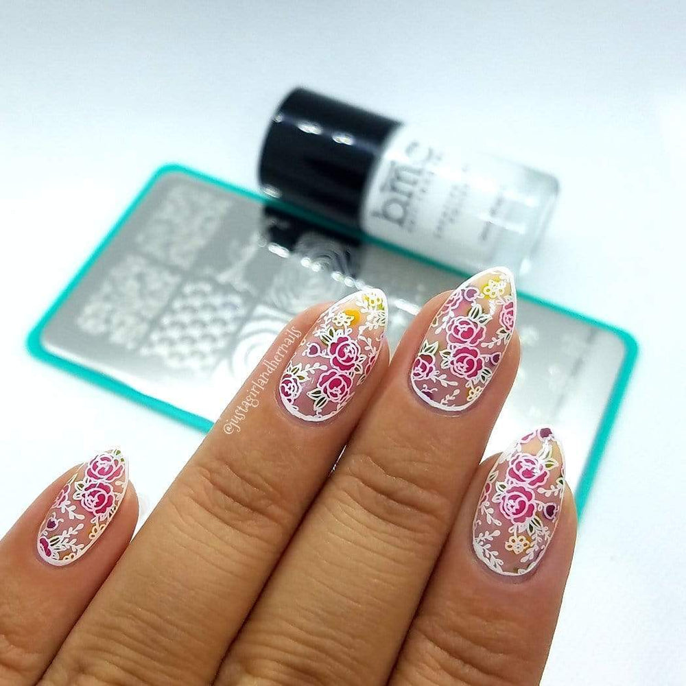 A manicured hand in rose gardens design over the stamping plate and polish.