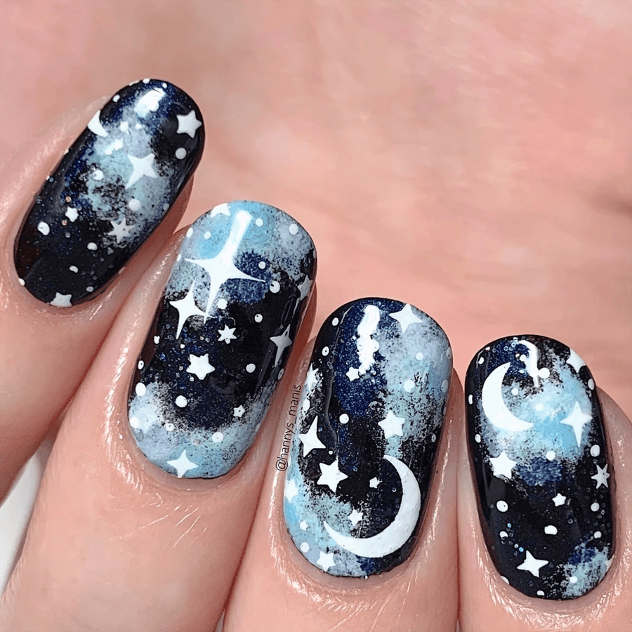 A manicured hand with stars and moon design by Maniology.