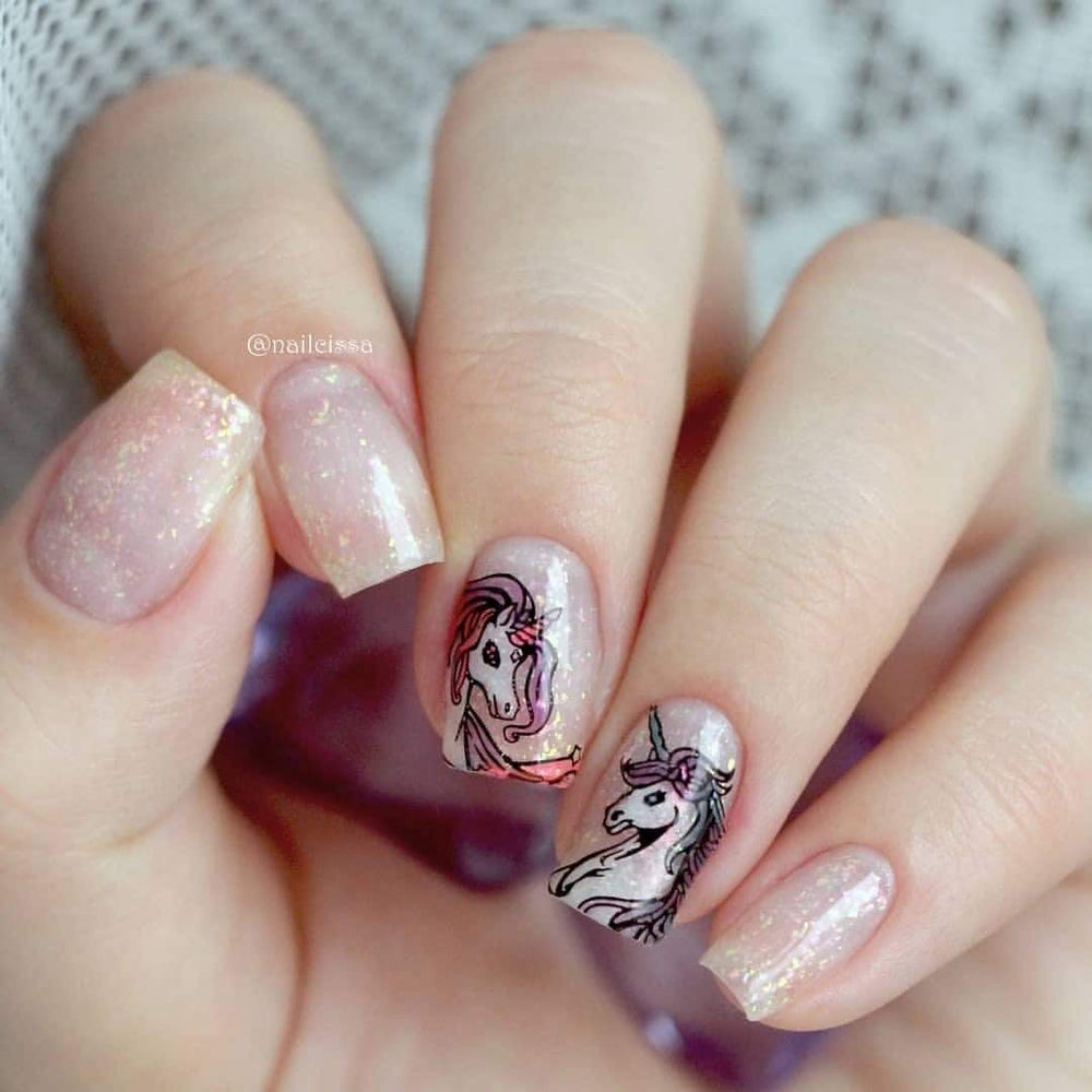 A manicured hand with unicorn design.