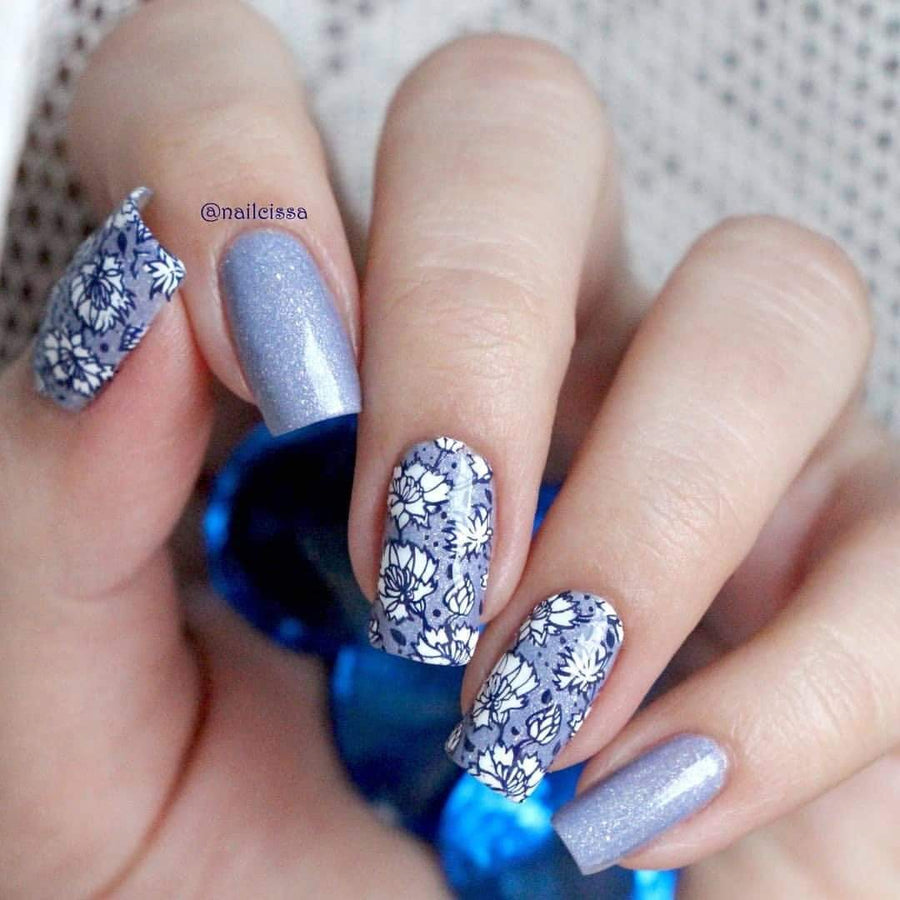A manicured hand in blue and white with floral designs.