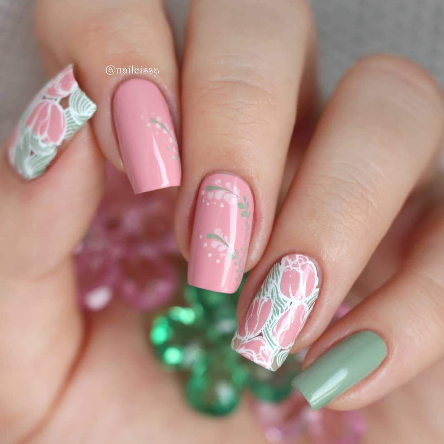 A manicured hand in pink and green with floral designs.