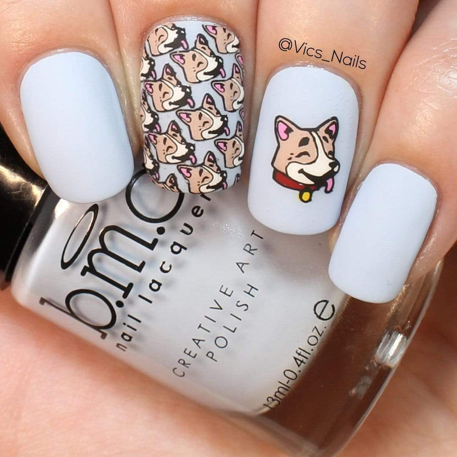 A manicured hand with dogs design holding a polish.
