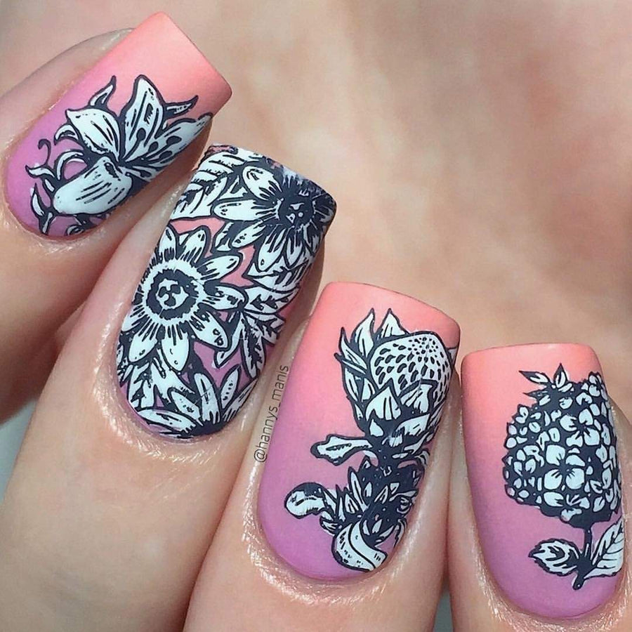 A manicured hand in pink and white with blooming flower designs. 
