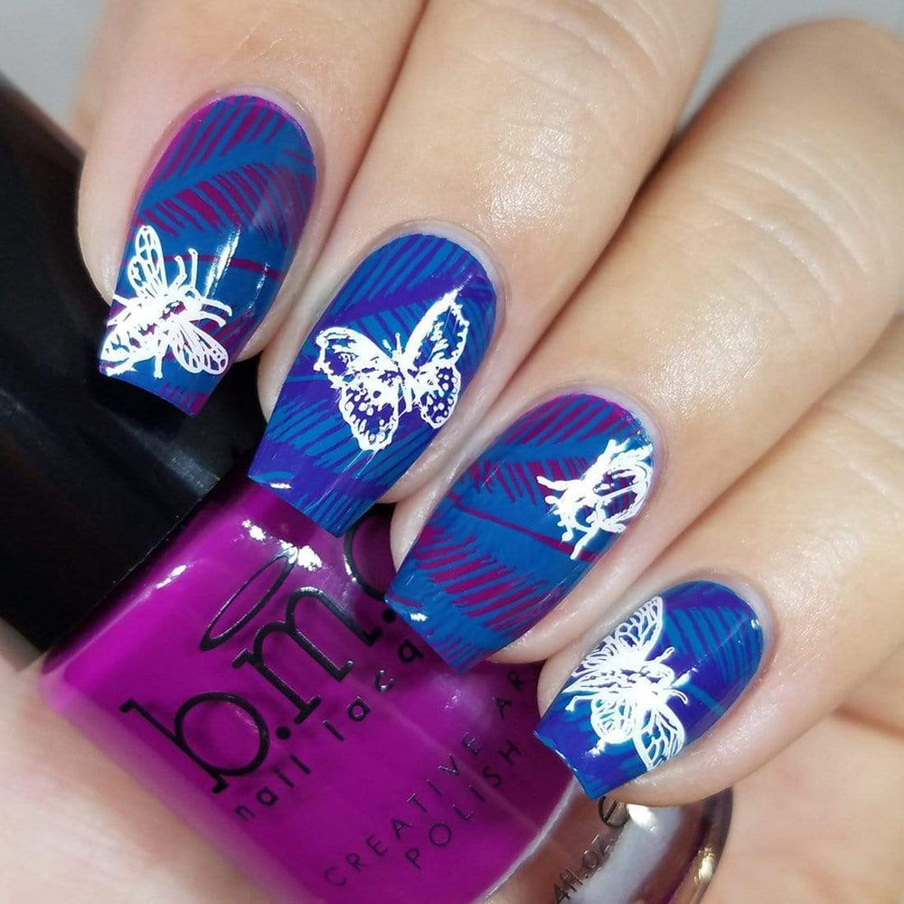 A manicured hand in blue with a flight of insects design holding a polish.