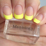 A manicured hand in yellow french tip design holding a stamper by  Maniology (m052).