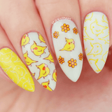 A manicured hand in yellow and white with parakeets design.