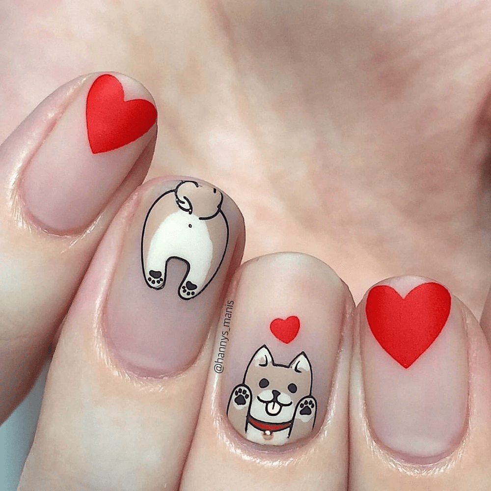 A manicured hand with puppy butts and hearts design by Maniology.