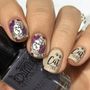 A manicured hand with flowers and cats design holding a polish.