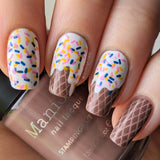 A manicured hand with sprinkles cupcake designs Sweet Thing (m100) holding a stamping polish by Maniology.