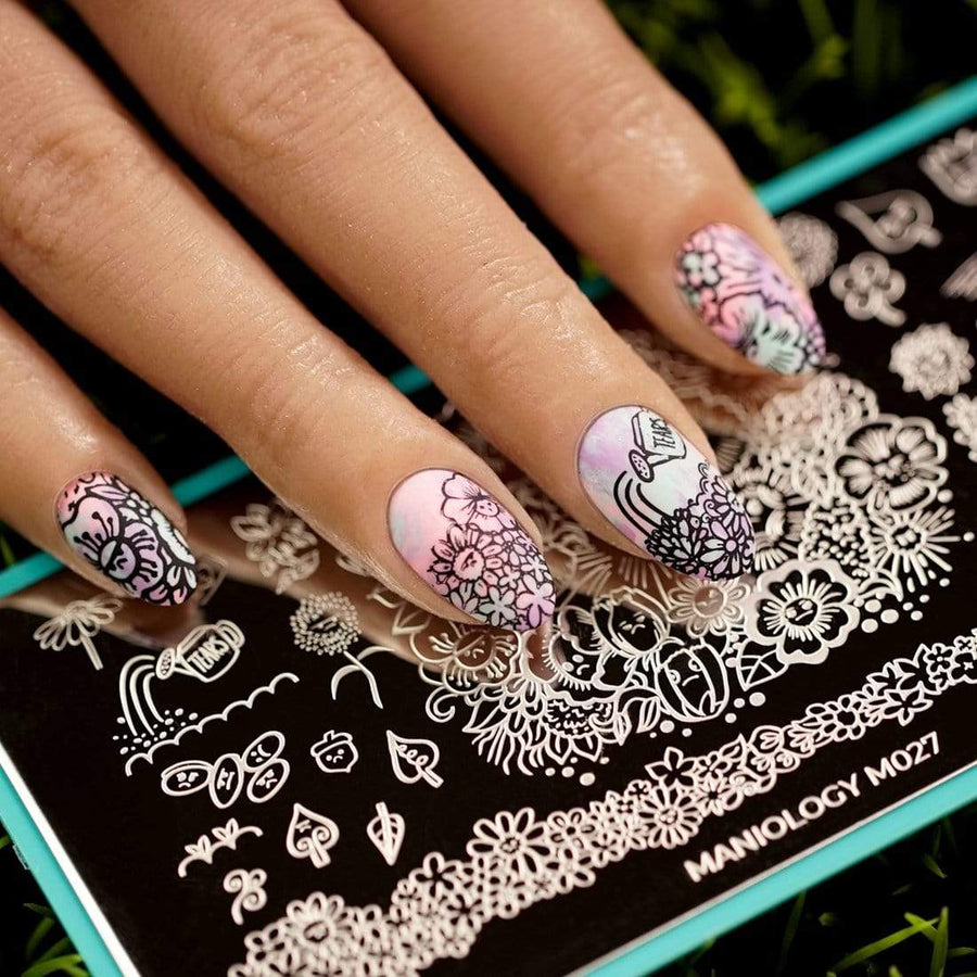 A manicured hand with the garden design over a nail stamping plate.