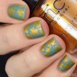 A manicured hand holding a Heart of Gold stamping polish