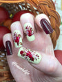 A manicured hand with florals Harvest Blooms design (m075) by Maniology.