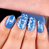 A manicured hand in blue with hearts, stars and horseshoe designs by Maniology (m013).