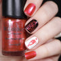  A manicured hand in red, white and black with a cherry and fruit juice design holding a polish by Maniology.