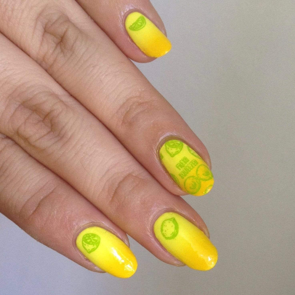 A manicured hand in yellow with simple different types of fruit designs.