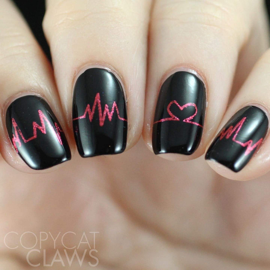 A manicured hand in black with heartbeat design by Maniology.