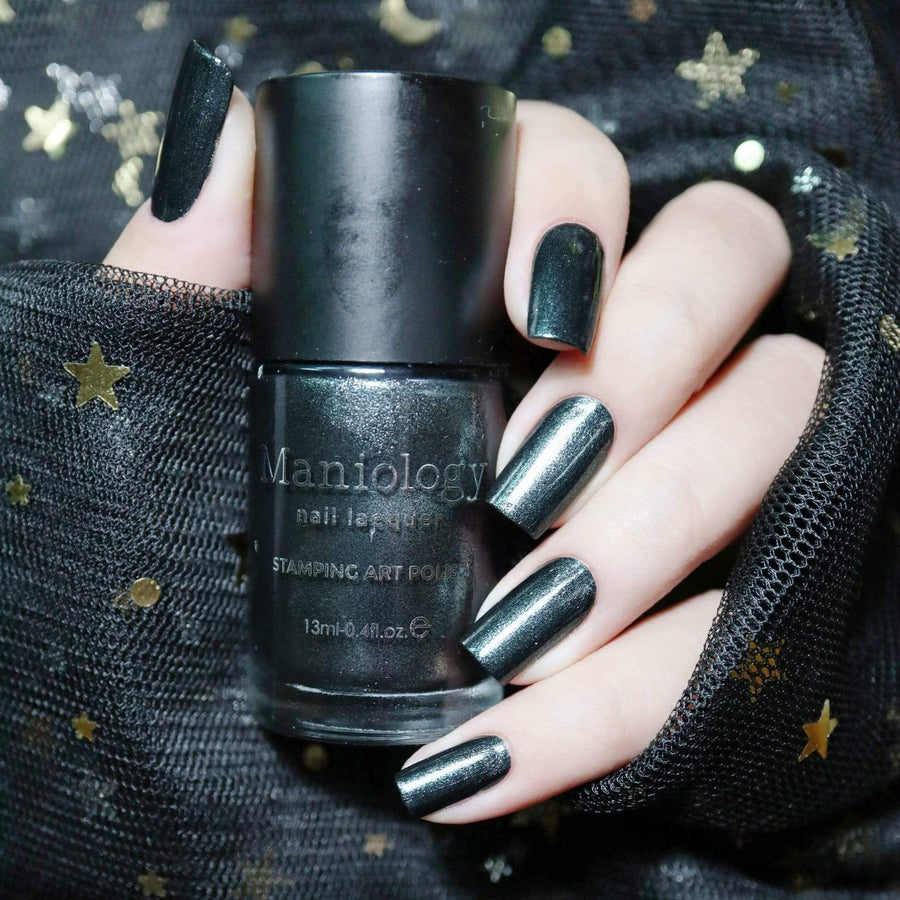 A manicured hand holding a Mirror, Mirror - Smoky Black stamping polish by Maniology.