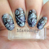 A manicured hand with bad to the bones designs holding a stamper by Maniology (m158).