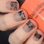 A manicured hand with Halloween: Fright Night design holding a polish by Maniology (m032).