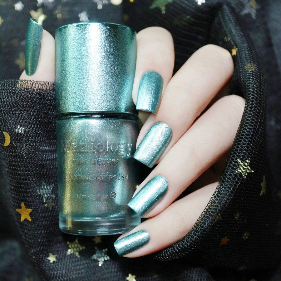 A manicured hand holding Baby Blue Metallic Stamping Polish Chill Out (B264) by Maniology.